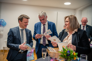 Bürgermeister Haarmann, Bürgermeisterin Eislöffel und noch ein Mann schauen sich die Jubiläumsmünze an 