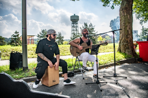 zwei Musiker singen und spielen draußen