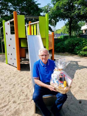 Wilhelm Kruismann auf Spielplatz mit Geschenkkorb Wilhelm Kruismann auf Spielplatz mit Geschenkkorb