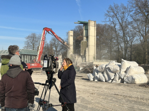 Bürgermeisterin hält Interview vor Baustelle