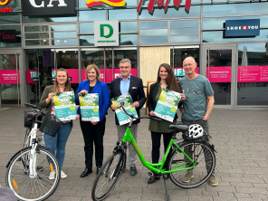 Gruppenbild mit grünem und weißem Fahrrad im Vordergrund vor der Neutor Galerie