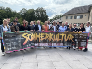Menschen halten großes Plakat zur Sommerkultur Menschen halten großes Plakat zur Sommerkultur