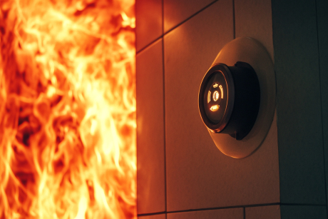 Feuermelder mit Feuer im Hintergrund Feuermelder mit Feuer im Hintergrund
