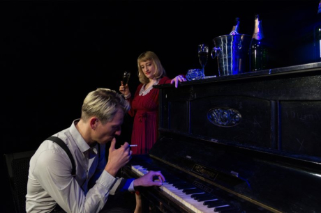 Mann am Klavier und Frau steht daneben Mann am Klavier und Frau steht daneben