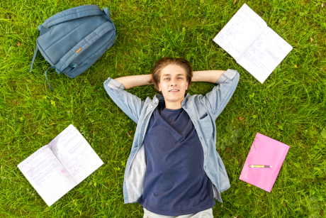 Gelassener Schüler auf einer Wiese Gelassener Schüler auf einer Wiese